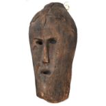A large hollow, carved human head, in the form of a mask with cut out eyes, long nose and cut out