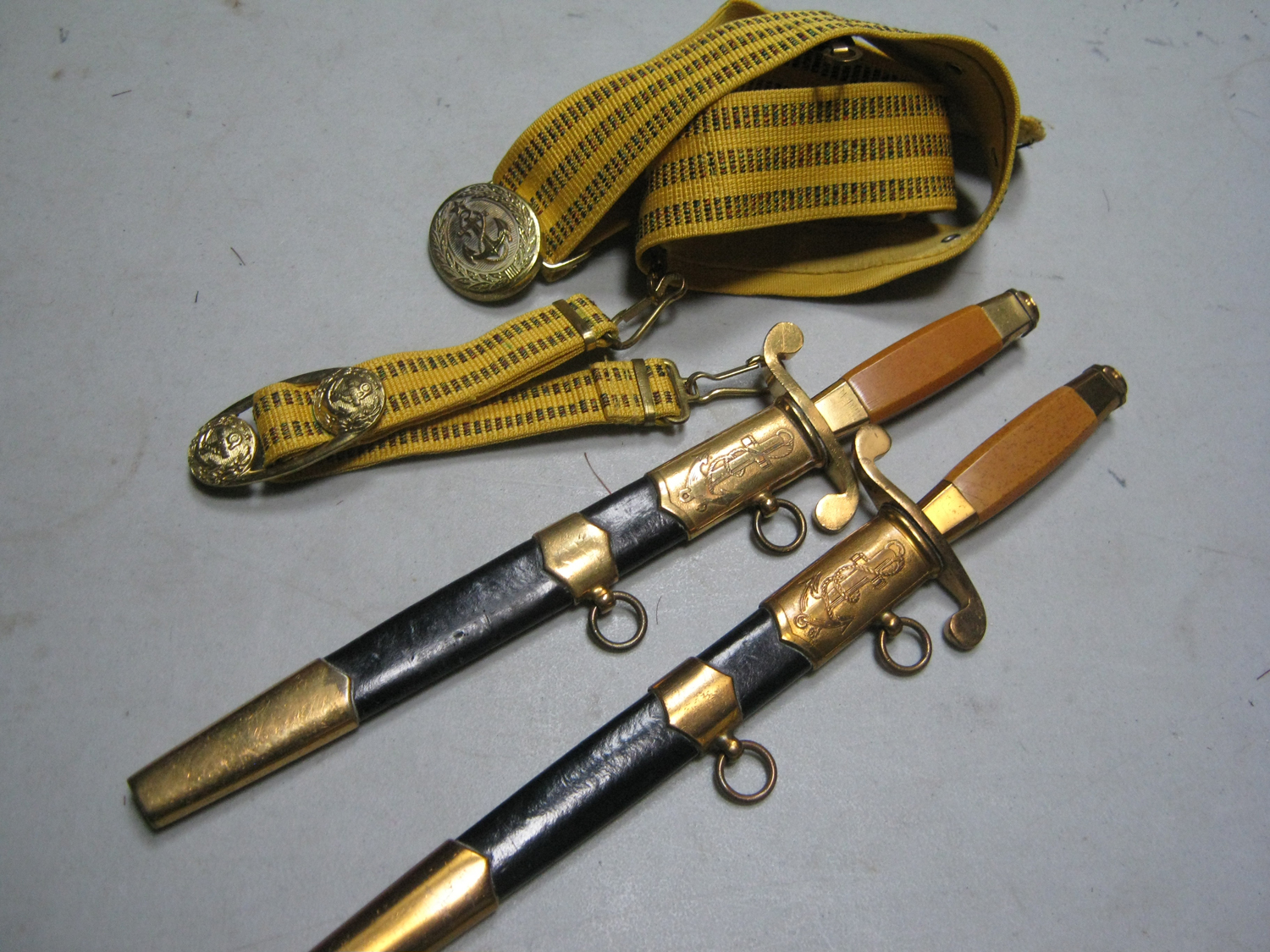 Two Soviet Russian naval daggers, the blades dated "1952" and "58", in their sheaths with brocade