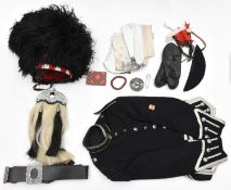 A Scottish piper's uniform: feather bonnet with 3 tails, red, white and blue diced wool headband,