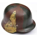 A German M35 steel helmet, the skull with camouflage painted finish and remains of single SS