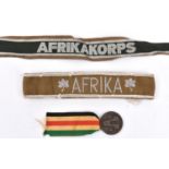 An Afrikakorps woven silver wire cuff title, VGC; and Afrika embroidered cuff title; and an Axis