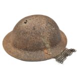 A British WWI Brodie steel helmet, in heavily corroded excavated condition, with wire rail and