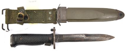 A US M8A1 bayonet, in its khaki composition scabbard with webbing belt loop. GC