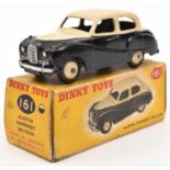 A Dinky Toys Austin Somerset Saloon (161). Cream upper body and wheels, with black lower body.