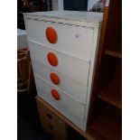 A retro white chest of drawers with big round orange handles