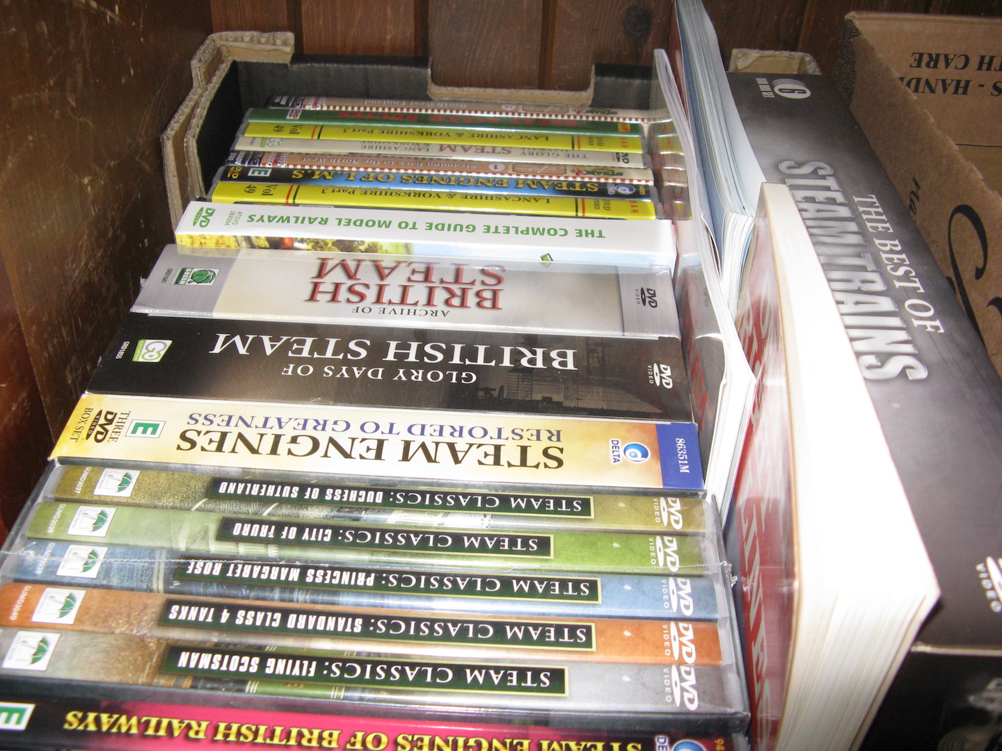 A box of books and DVDs related to steam trains