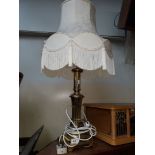 A brass base table lamp and shade