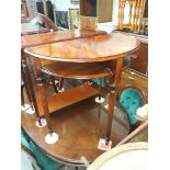 A reproduction mahogany demi lune table on reeded legs