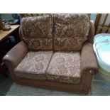 A brown floral patterned 2 seater sofa