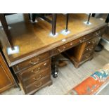 An oak pedestal desk with tooled leather top