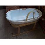 A moses basket on stand and a baby bath