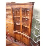 A mahogany concave front corner display cabinet