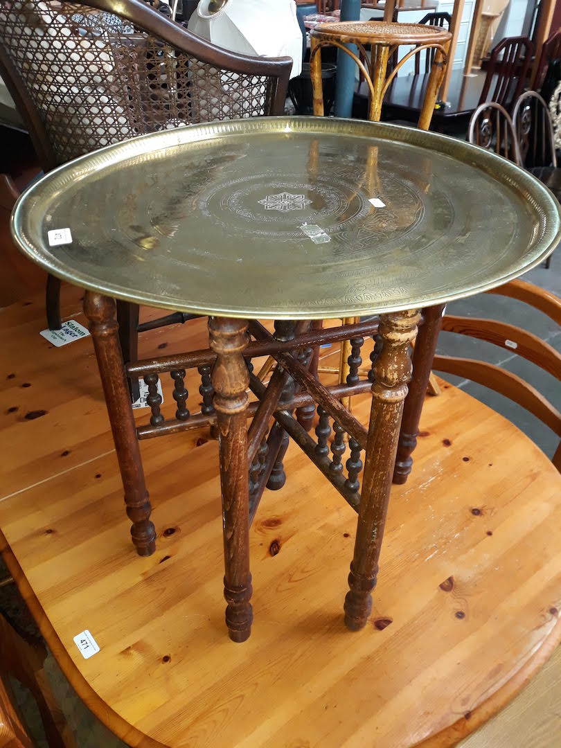 An eastern style folding brass top table