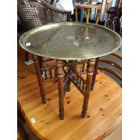 An eastern style folding brass top table