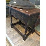 A carved oak stool with lift top.