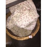 A basket with contents to include throws, quilt, etc
