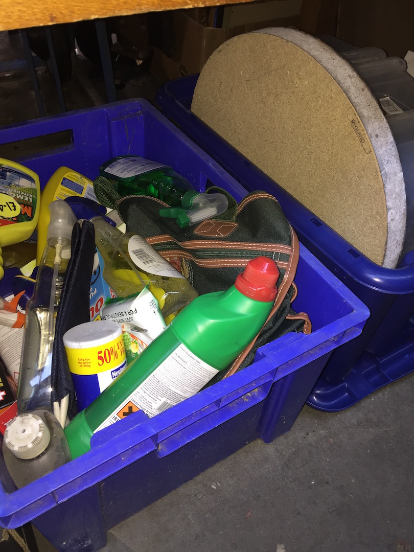 A box of storage plastic boxes and a darts board