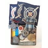 A tin of mainly life saving medals and badges.