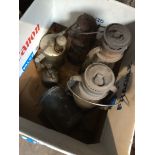 A box containing few vintage lamps, blow torches and an oiler