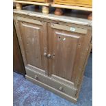 A pine cabinet with lower drawer