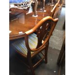 A reproduction yew wood extending dining table and eight chairs