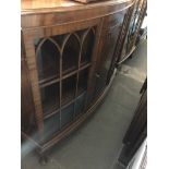 A 1920s bow front glazed display cabinet