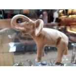 A miniature Royal Dux elephant, length 8cm.