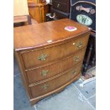 A reproduction bow front chest of drawers