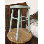 A wooden stool painted in mint green