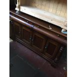 A reproduction cherry wood sideboard.