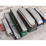 A group of seven vintage harmonicas.