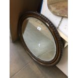 An oval framed mirror.