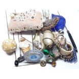 A group of vintage hat pins, a pin cushion and a blue glass scent bottle formed as a shell.