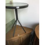 A patio metal and glass top table with 2 metal and mesh chairs