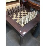 A chess and backgammon table with Chinese style chess pieces.