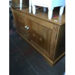 A two door pine cabinet with pot handles, width 154cm, depth 64cm & height 89cm.