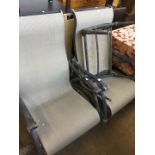 A pair of garden/patio armchairs on swivel bases with stool