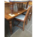 An oak extending dining table and 4 ladder back chairs