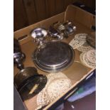 A box of plated ware and crochet coasters with glass base