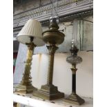 Two oil lamps and a brass corinthean column table lamp