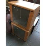 A pair of bedside cabinets with glass doors