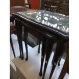 A reproduction glass top nest of tables
