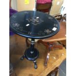 An ebonised hand painted wine table