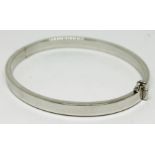 A contemporary hallmarked 9ct white gold bangle, approx. diam. 58mm, wt. 10.2g. Condition - very