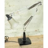 An early 20th century anglepoise lamp with cast metal base, white arm and glass shade.