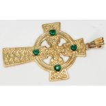 A 9ct gold Celtic style cross set with green stones, marked '9K' and also with 9ct gold import