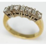 A seven stone diamond ring comprising four round brilliant cut diamonds interspersed by three