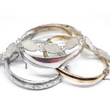 Three hallmarked silver bangles and a white metal mounted three pence bracelet.