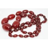 A single strand of cherry amber bakelite beads, ranging in length from 13mm - 28mm, length 72cm,