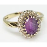 An amethyst and diamond cluster ring, the oval cut central stone approx. 8mm x 6mm, depth 4.66mm,